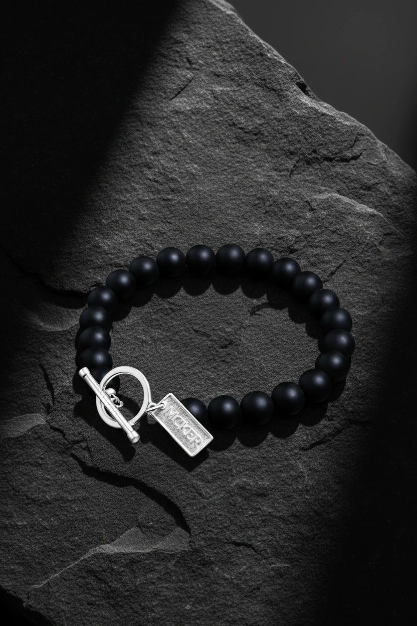 men's black bead bracelet with sterling silver toggle clasp on dark stone background