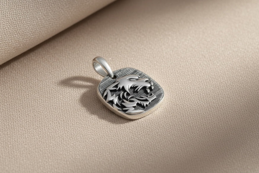 MCKER cheetah pendant with intricate design on a beige fabric background