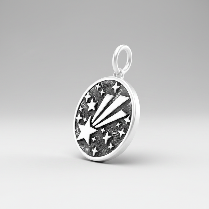 Shooting star pendant at an angle on light grey background, displaying dimension and metallic finish