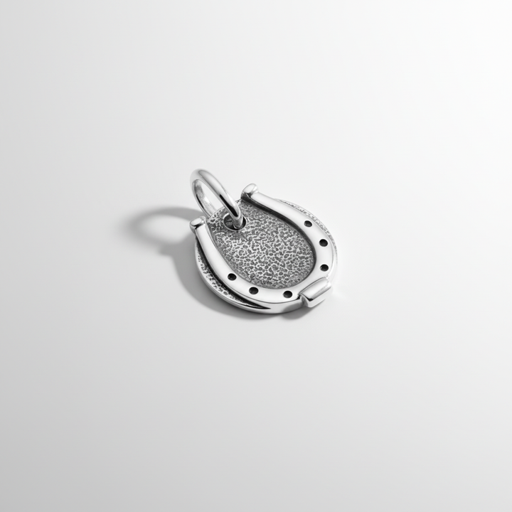 Close-up of men's sterling silver horseshoe pendant with artisan craftsmanship details