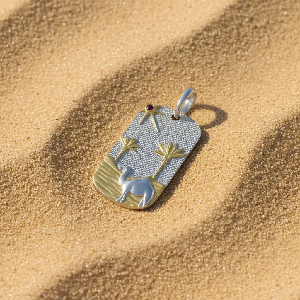 Sahara pendant with silver, gold vermeil and red stone detail on sand