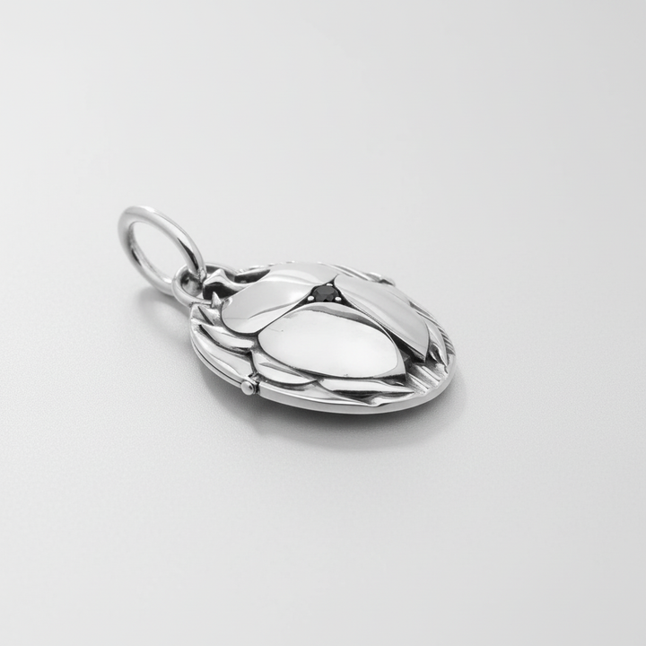MCKER scarab pendant angled view displaying dimensional craftsmanship and textured sterling silver beetle features.